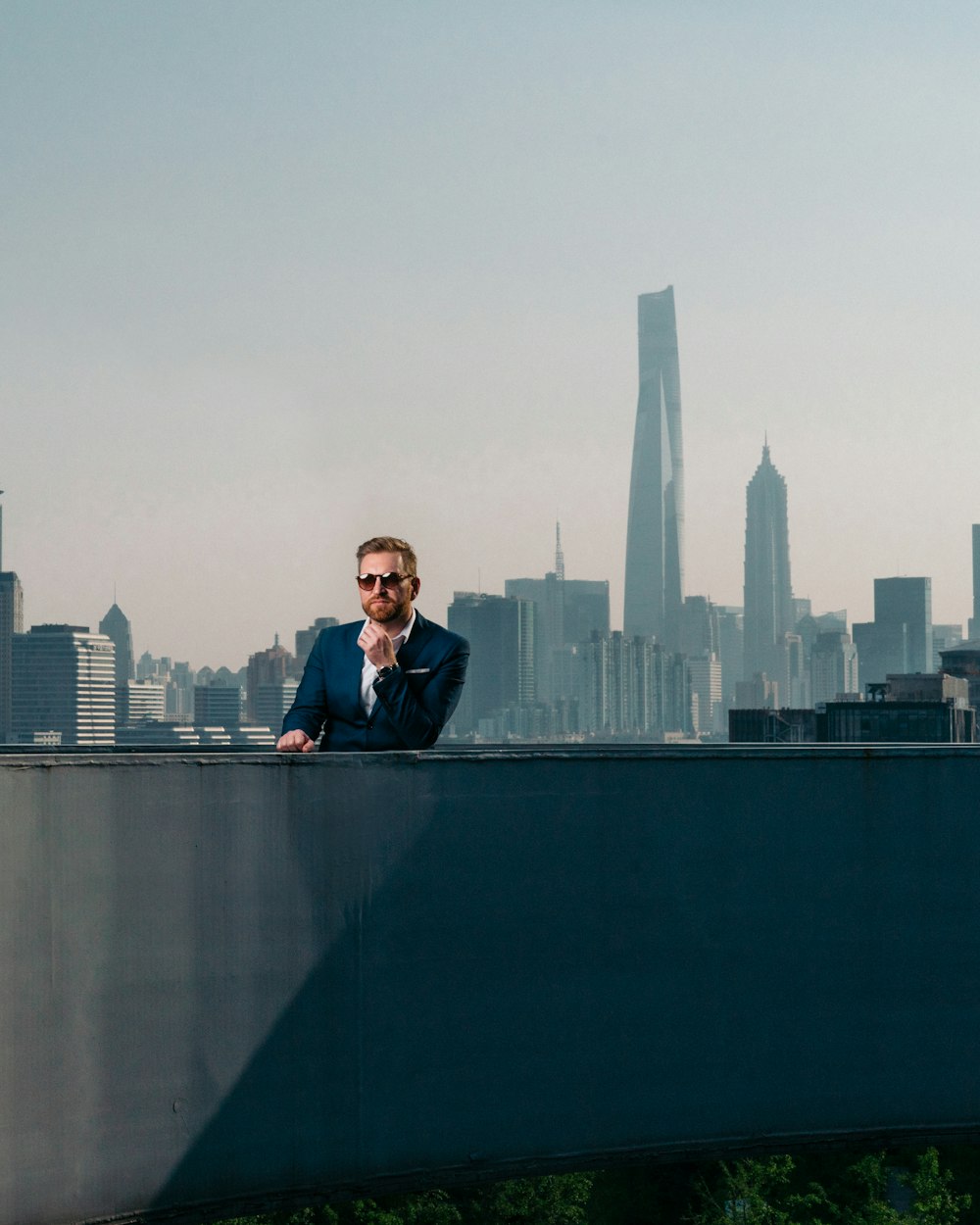 man in black suit jacket standing on top of building during daytime