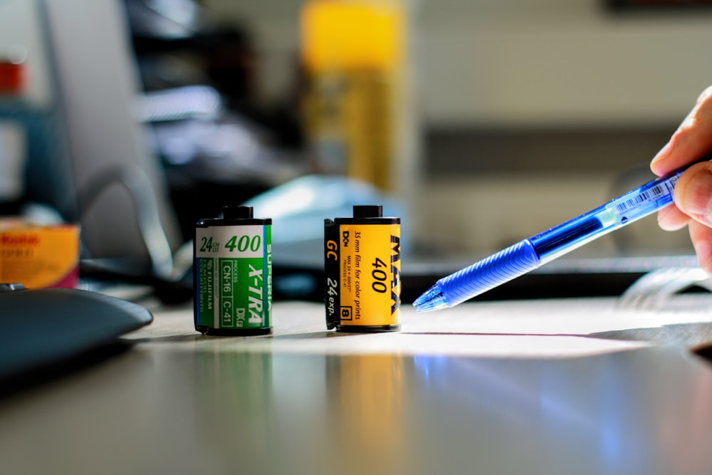 selective focus photography of two green and black cans on table