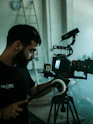 man in black crew neck t-shirt holding black dslr camera