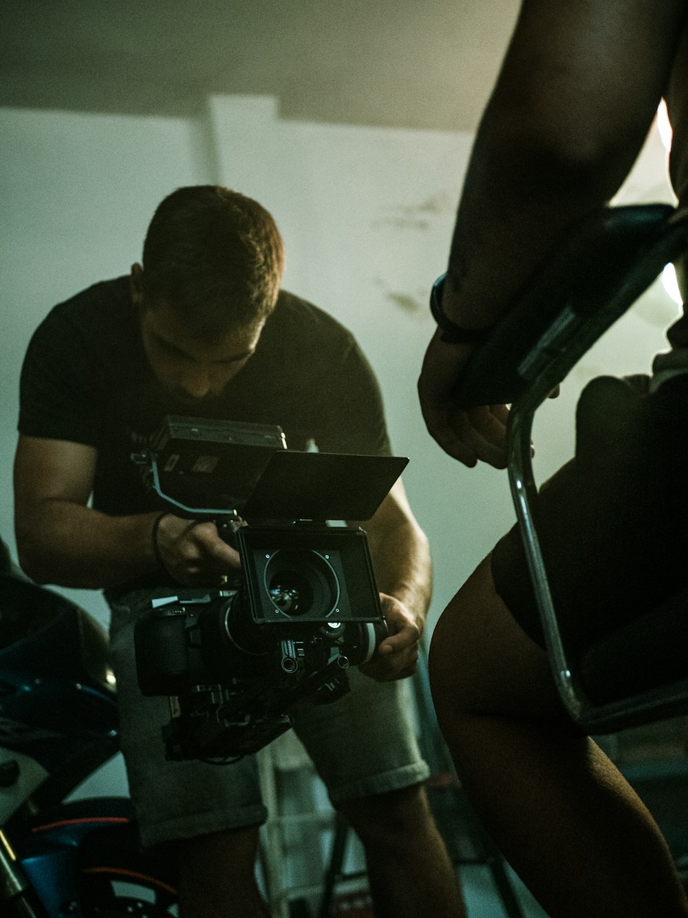 man in black crew neck t-shirt holding black camera