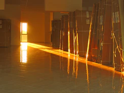 A smiling family unpacking boxes in their new home, sunlight streaming through large windows.
