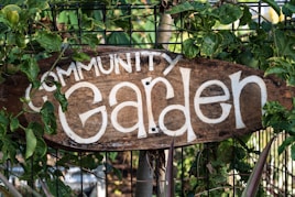 brown wooden welcome signage on green plants