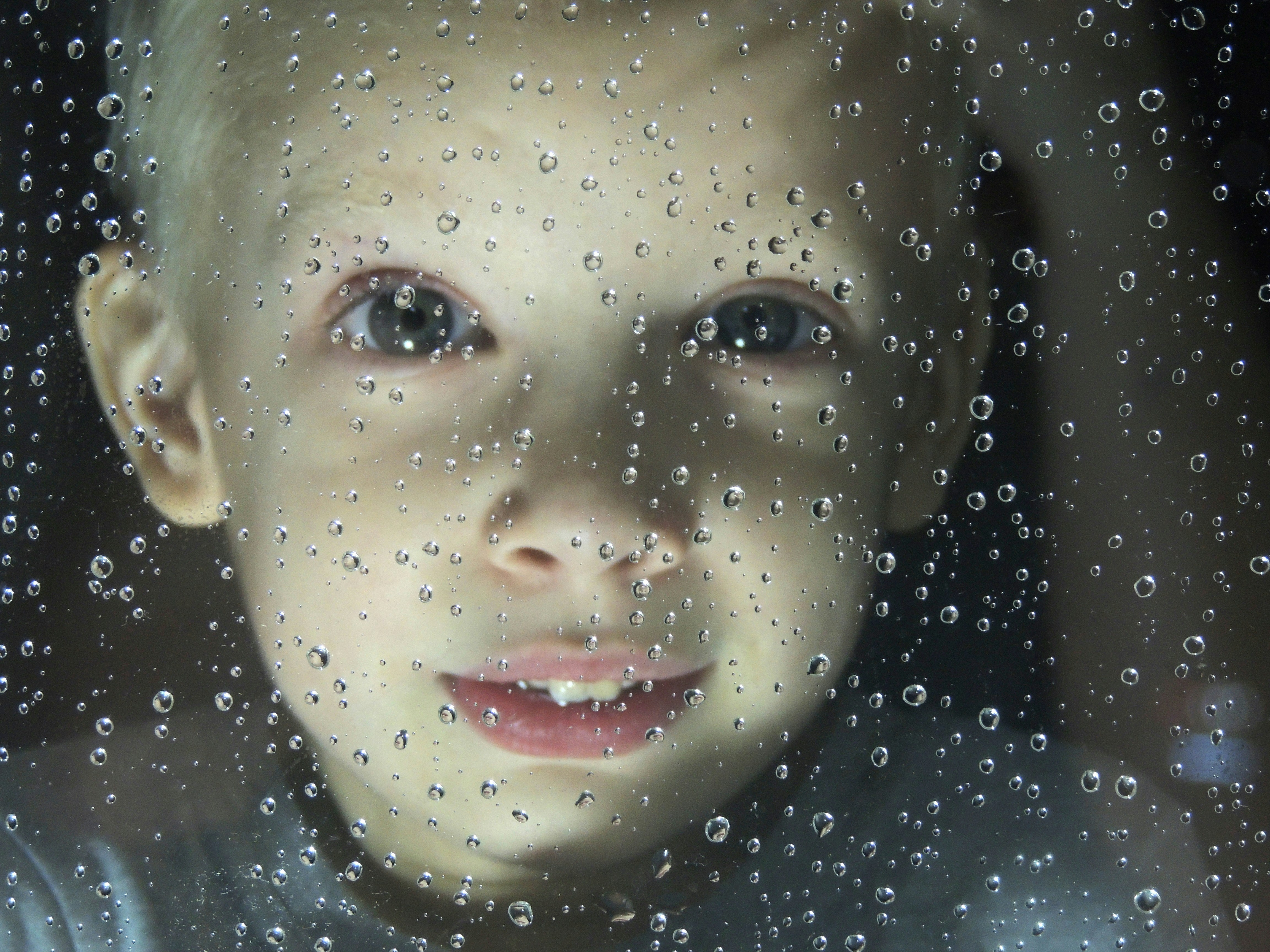 The boy looks through the glass splashed with rain drops. █ Мальчик смотрит сквозь стекло забрызганное каплями дождя.