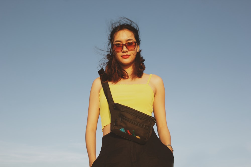 woman in yellow tank top and black skirt smiling