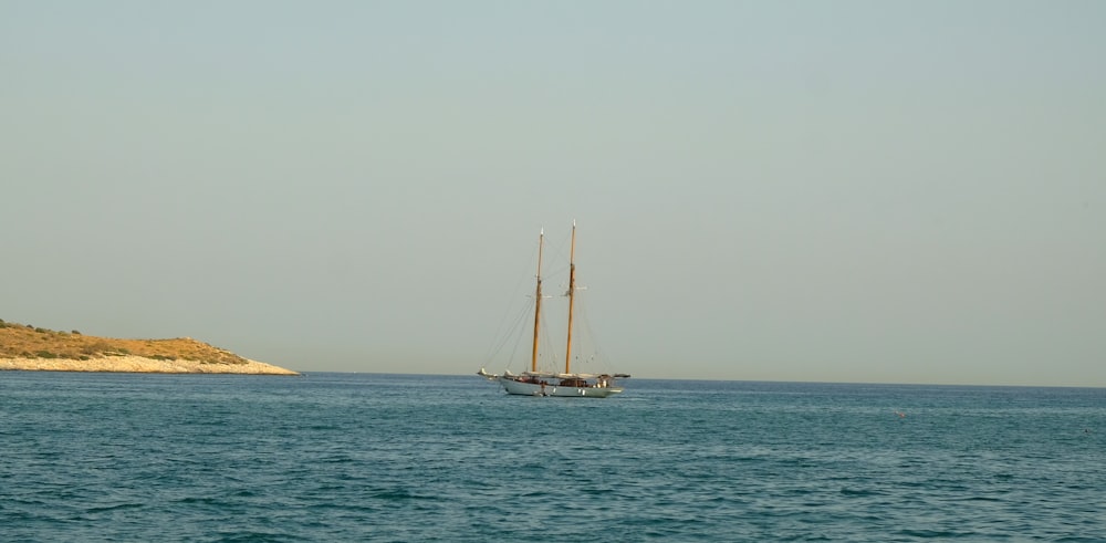 white sail boat on sea during daytime