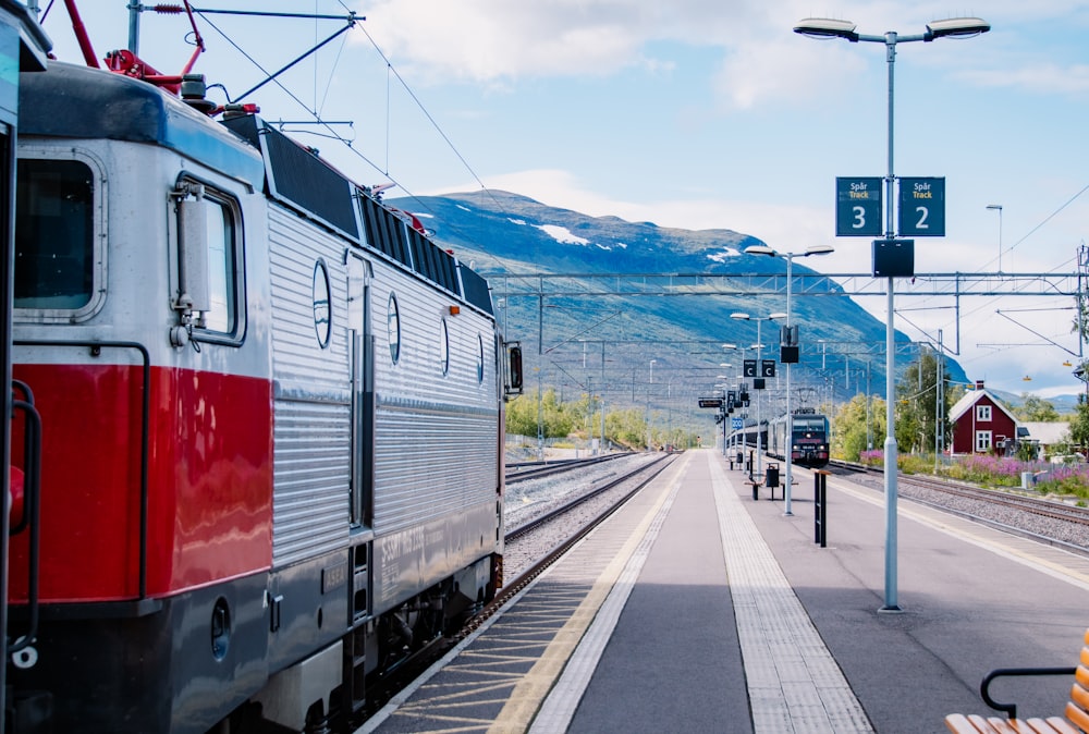 red and white train on rail tracks during daytime