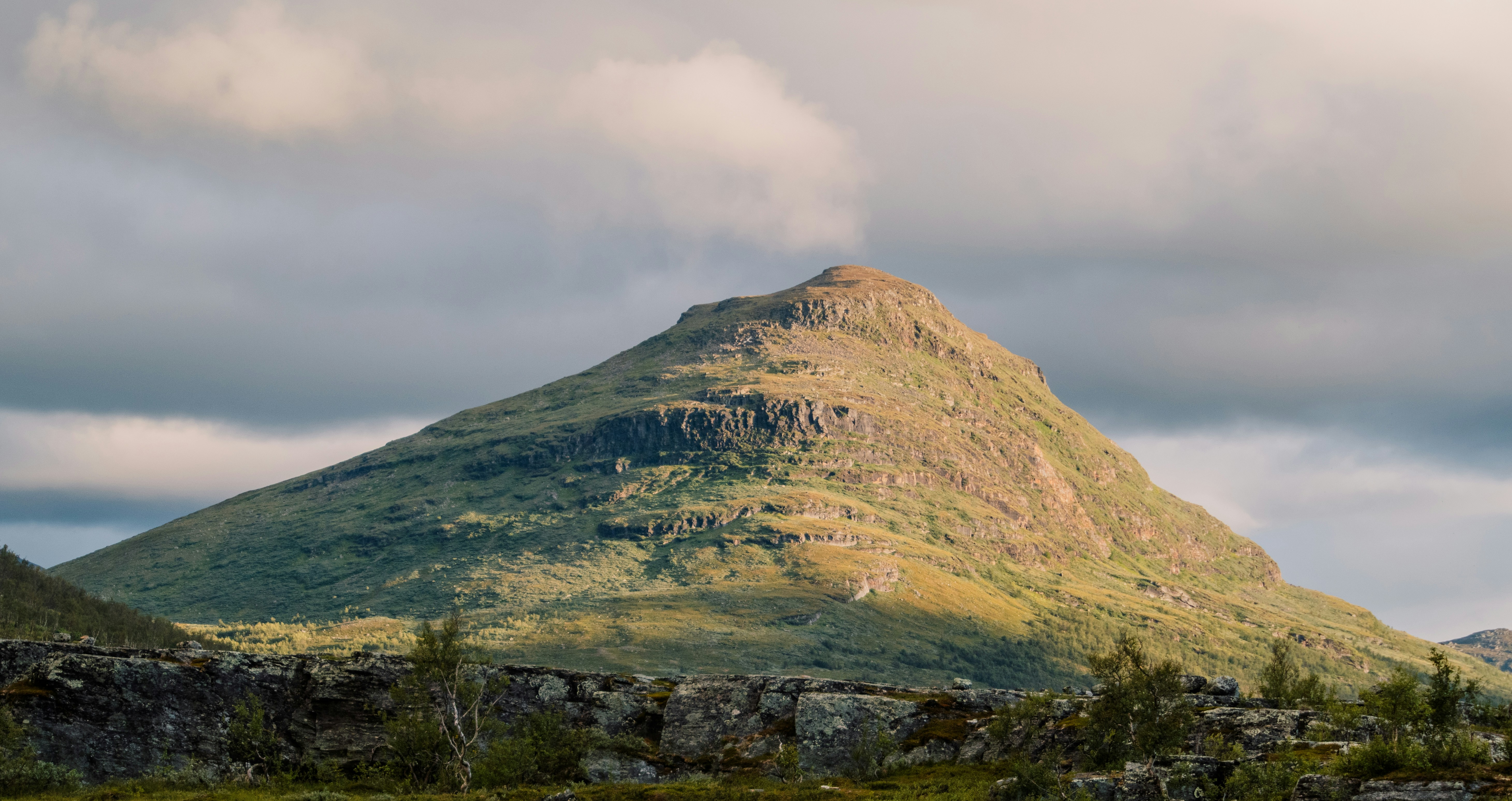 green mountain under white clouds during daytime, Gárddenvárri mountain near Abisko National Park in sweden