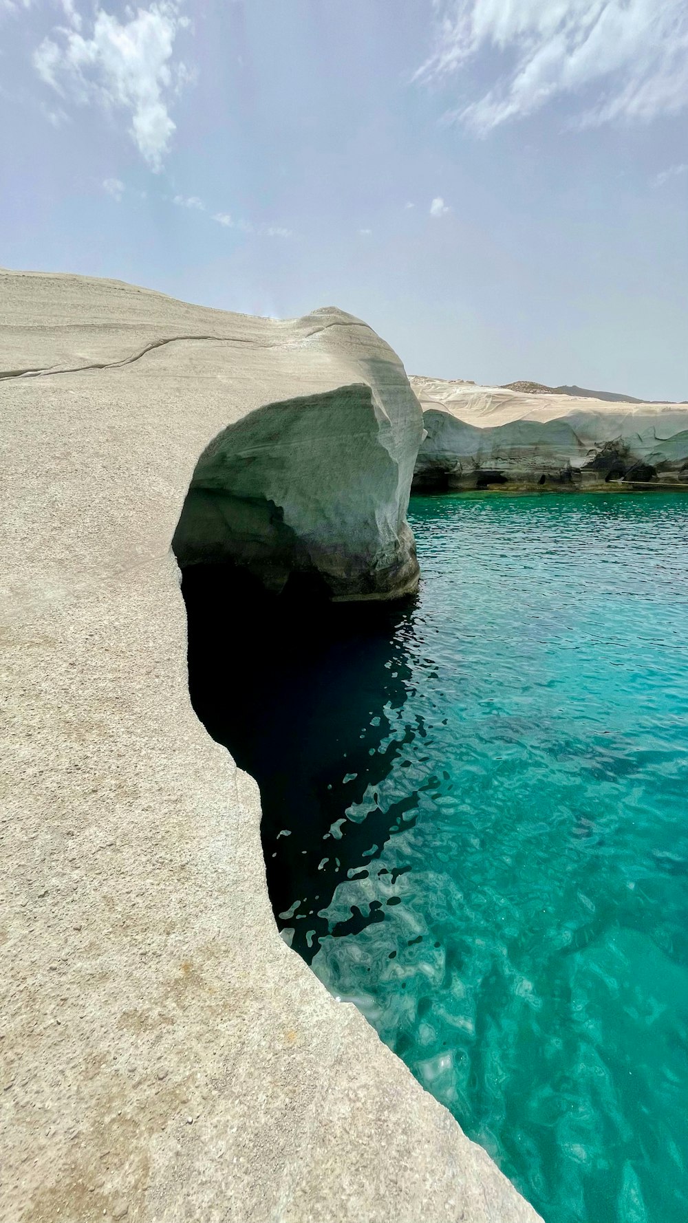 gray rock formation on body of water during daytime