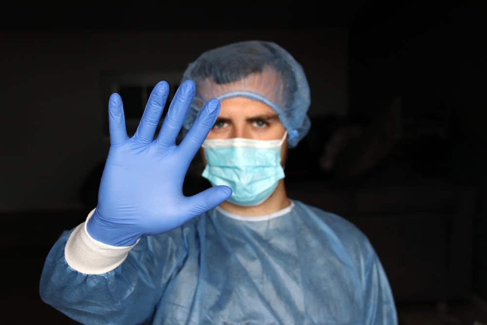 person in blue long sleeve shirt covering face with hand