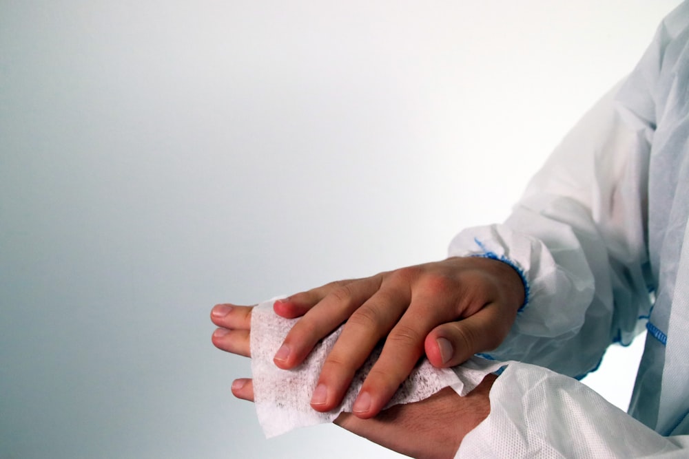 person in white long sleeve shirt holding white tissue paper