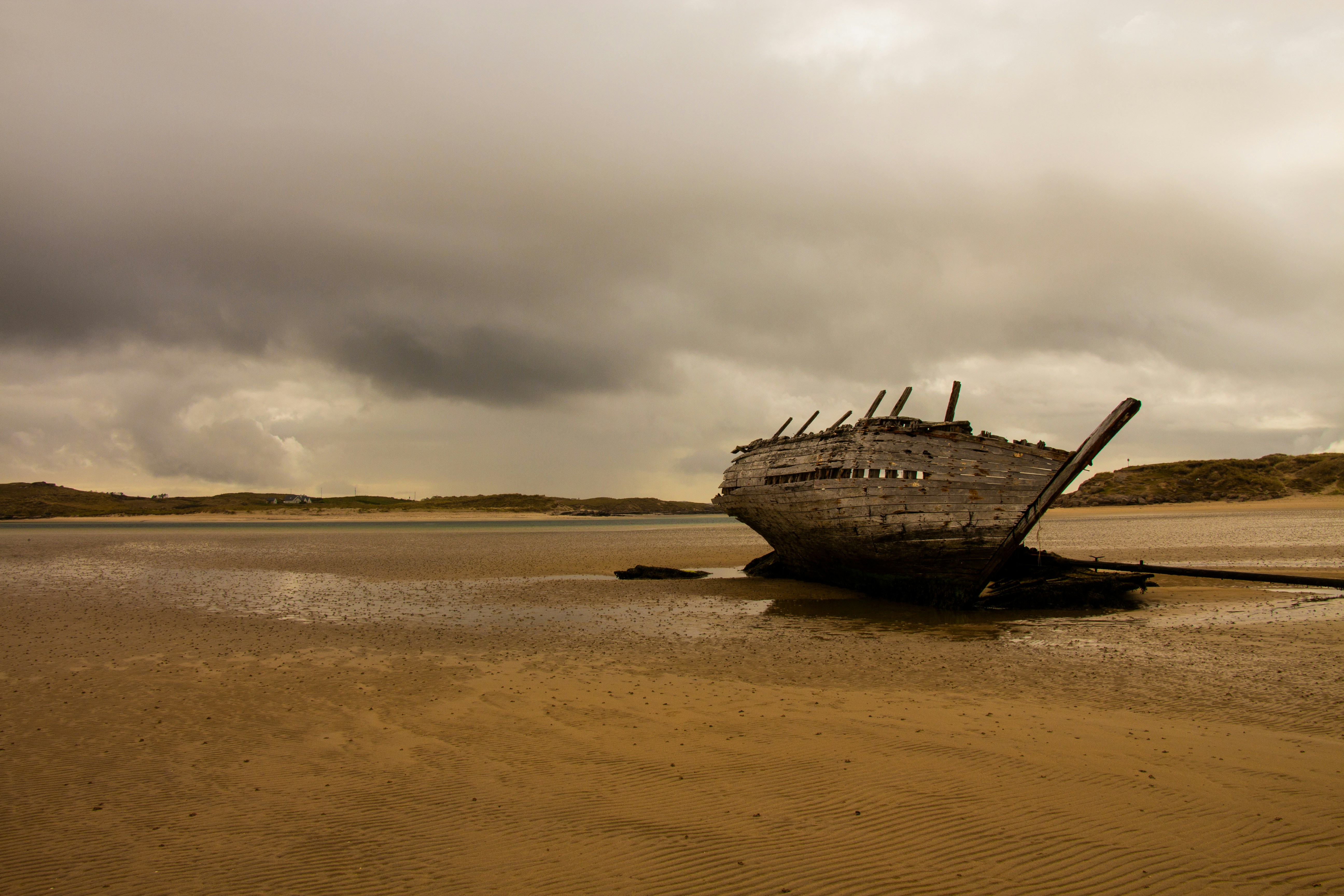 brown ship on brown sand under white clouds during daytime, Shipwreck on the beach in Ireland.