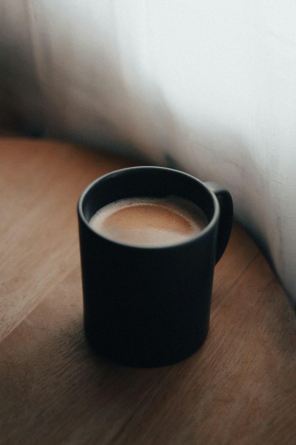 black ceramic mug on brown wooden table