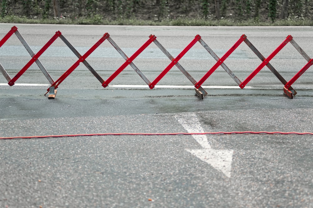 red and white wooden fence on gray concrete road