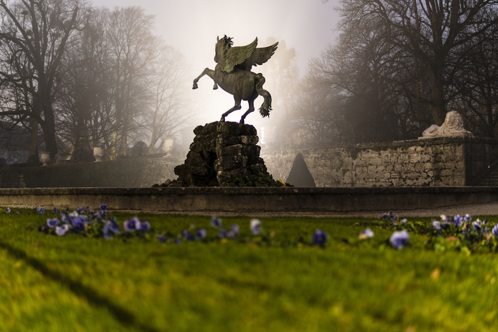 man riding horse statue on green grass field during daytime