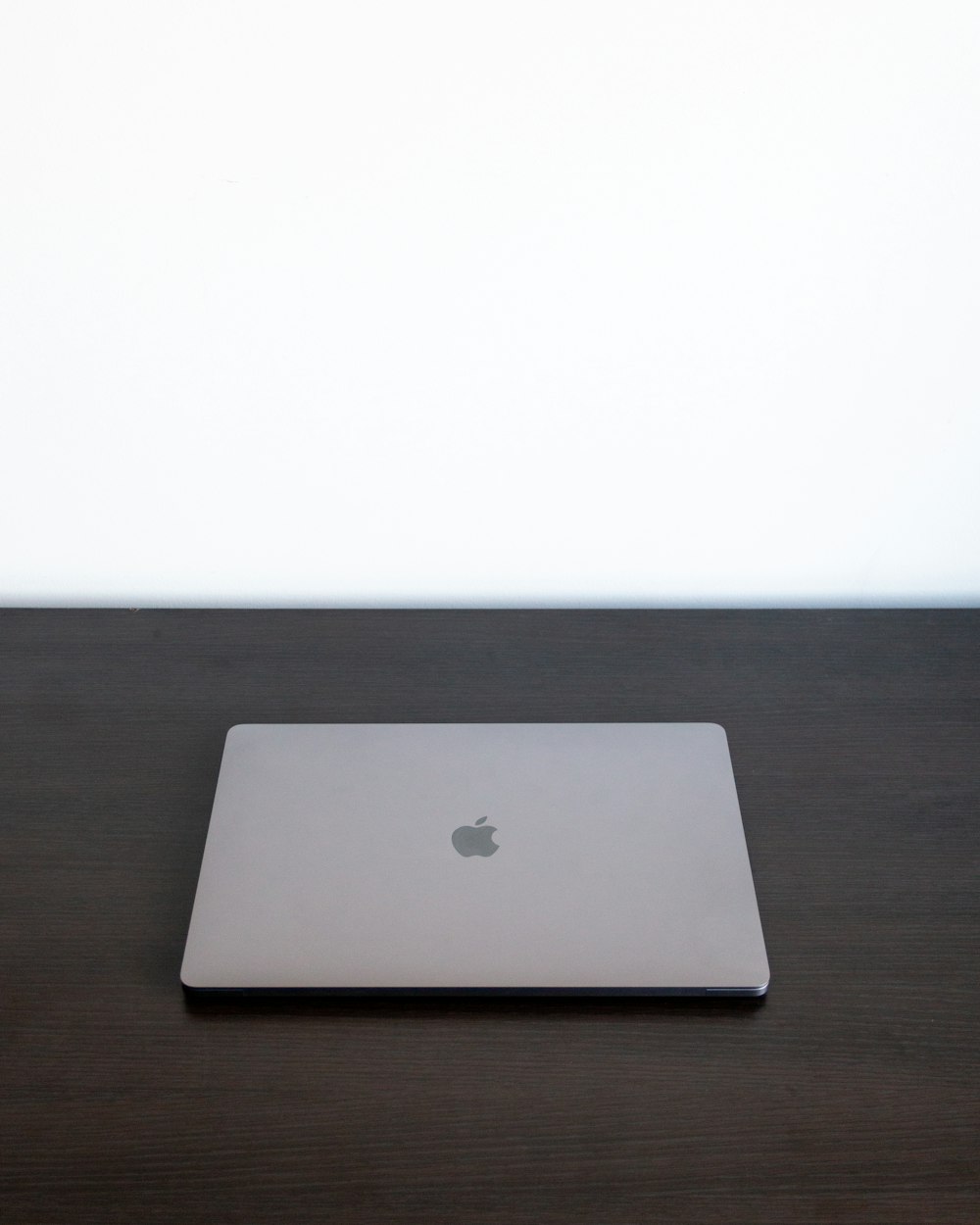 silver macbook on brown wooden table