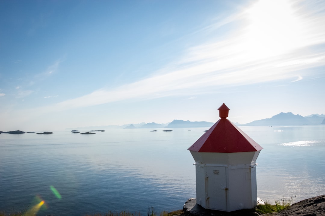 white and red concrete building near body of water during daytime