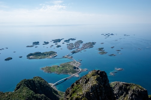 aerial view of green and brown mountain beside body of water during daytime