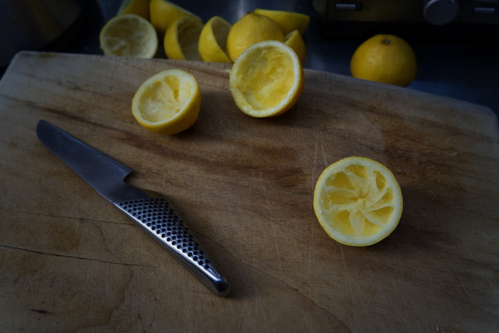 sliced lemon beside silver bread knife on brown wooden table