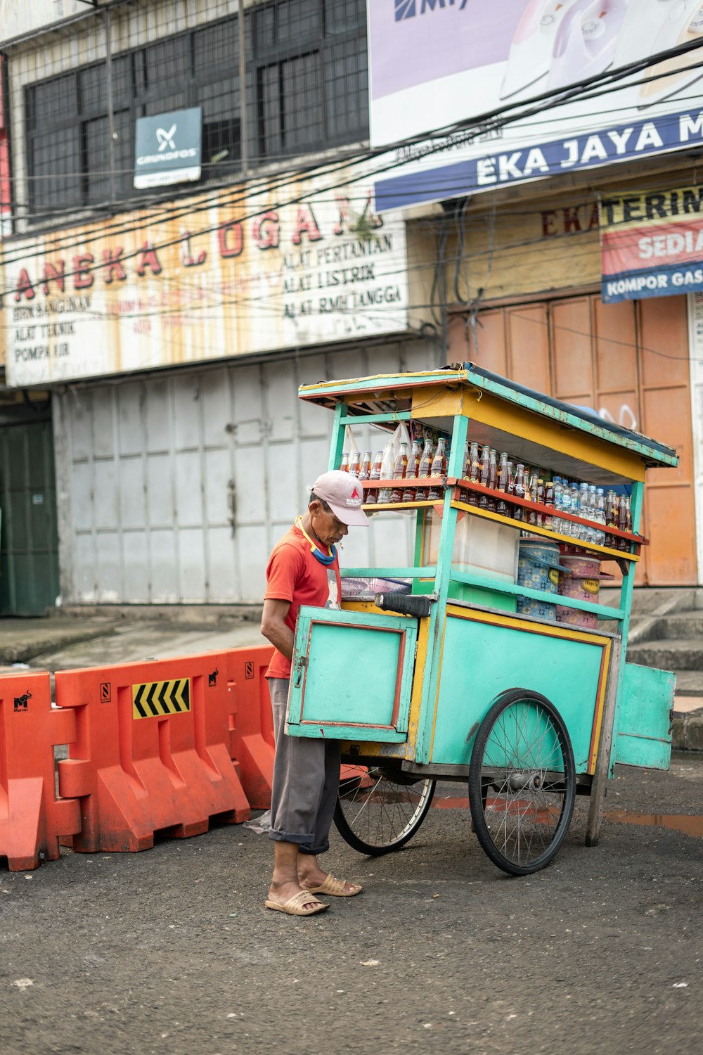 Hombre con camisa roja y pantalones negros montando en bicicleta durante el día