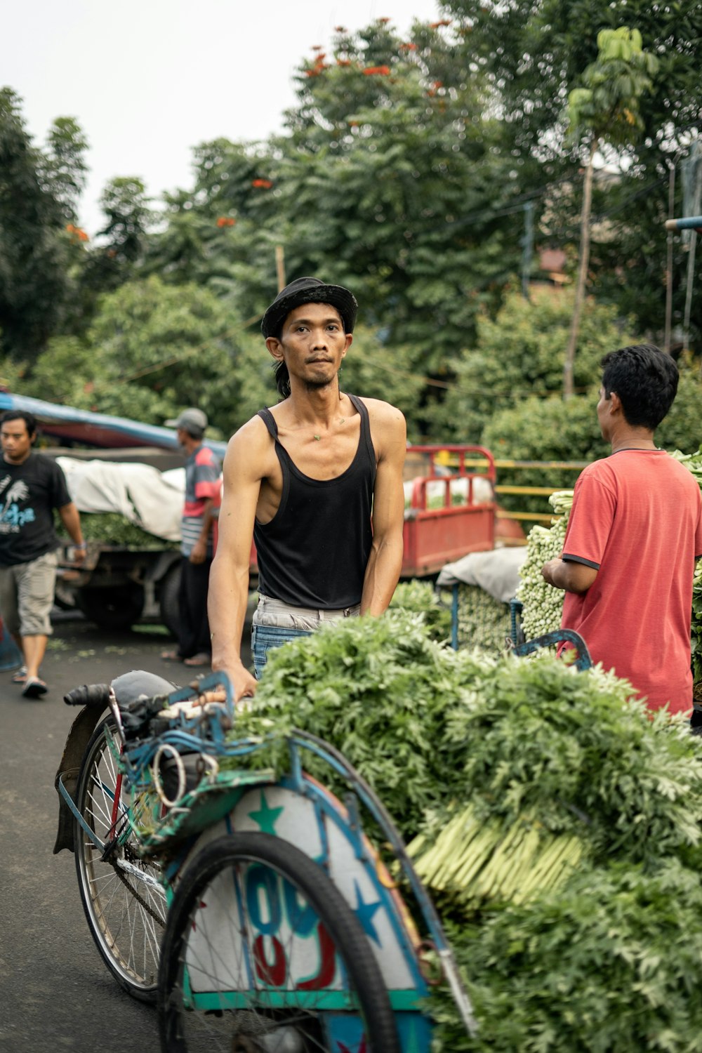 woman in black tank top holding green vegetable