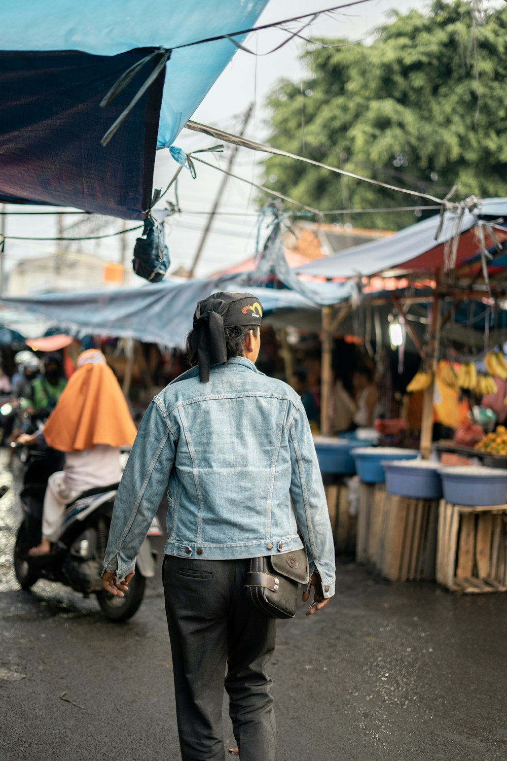 man in blue denim jacket standing on street during daytime