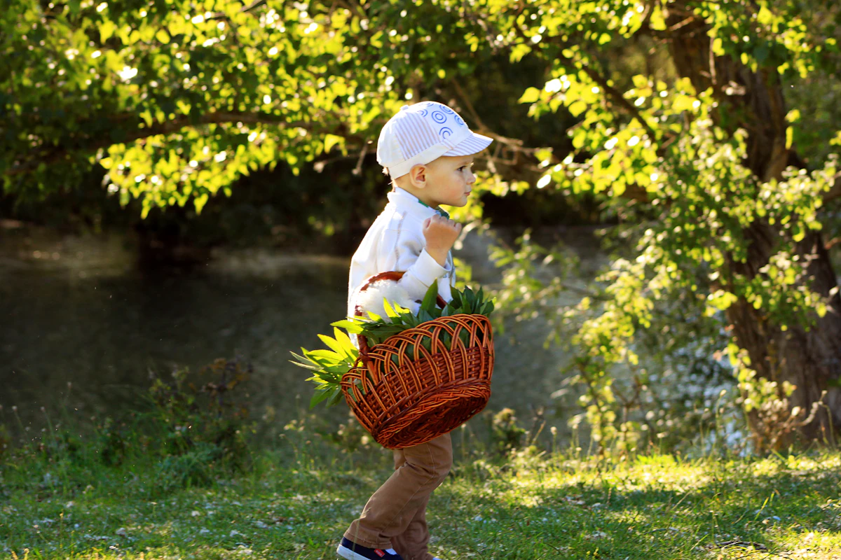 Toddler carrying a basket outdoors while collecting items on a nature walk
