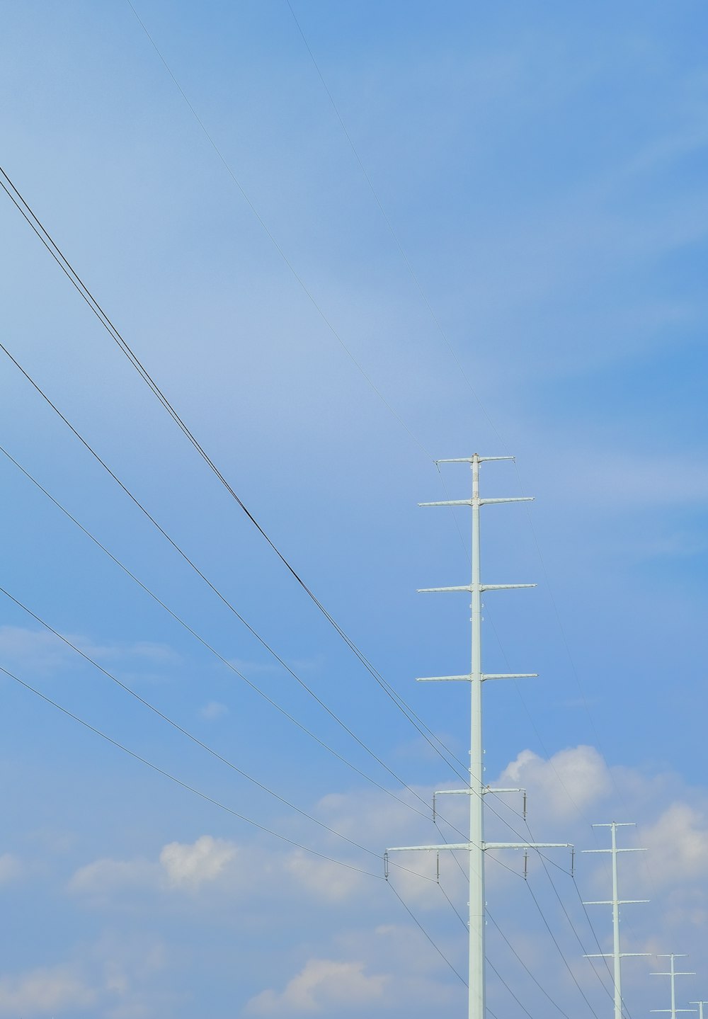 white electric post under blue sky during daytime