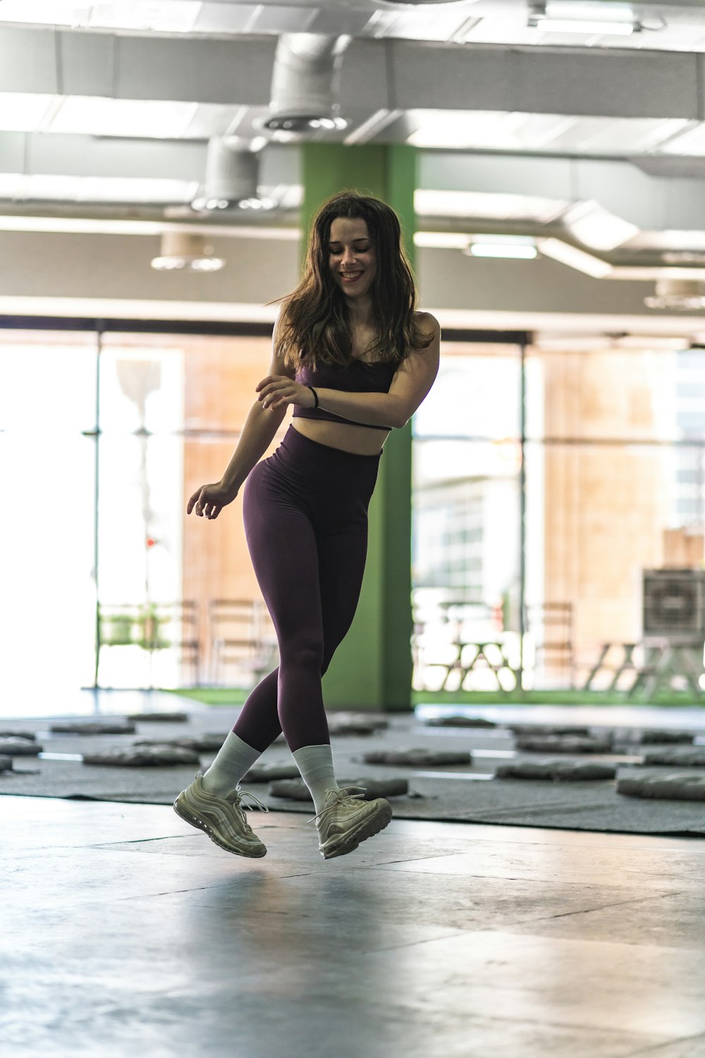 woman in black tank top and black leggings standing on gray concrete floor