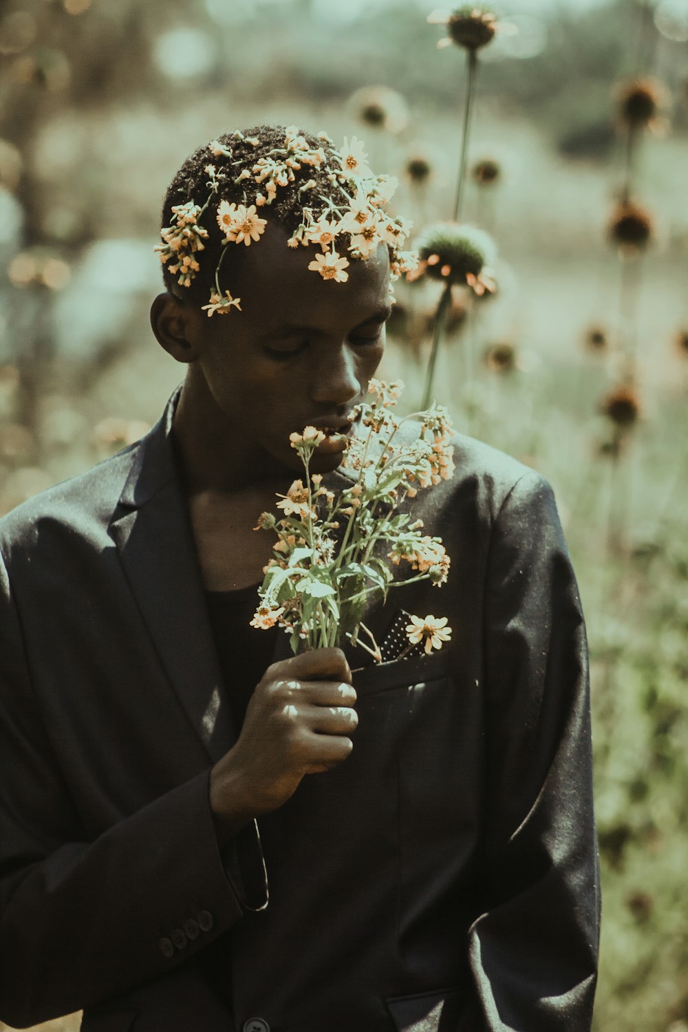 uomo in giacca abito nero con fiore bianco sull'orecchio