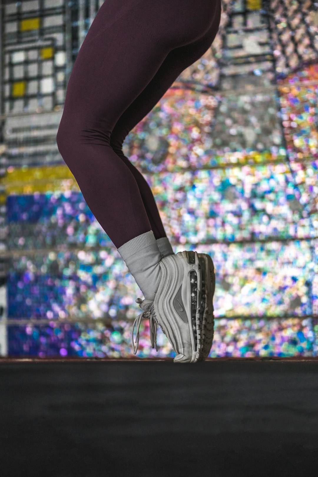 person in black leggings and black and white nike sneakers