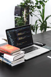 A professional workspace with notebooks and coding books neatly arranged.