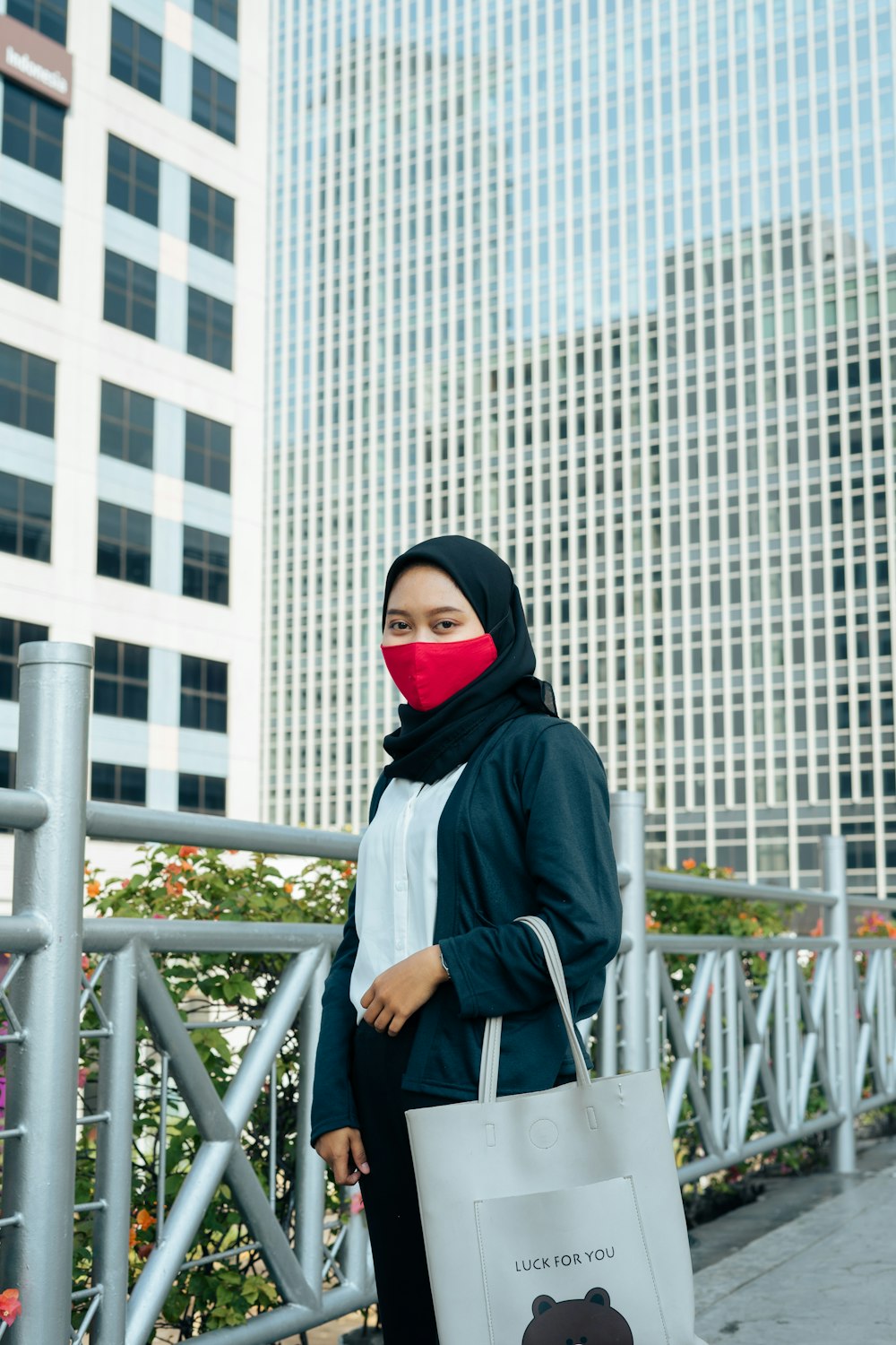 woman in black hijab standing near white metal railings