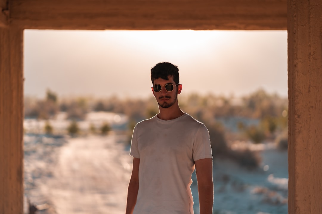 man in white crew neck t-shirt wearing black sunglasses