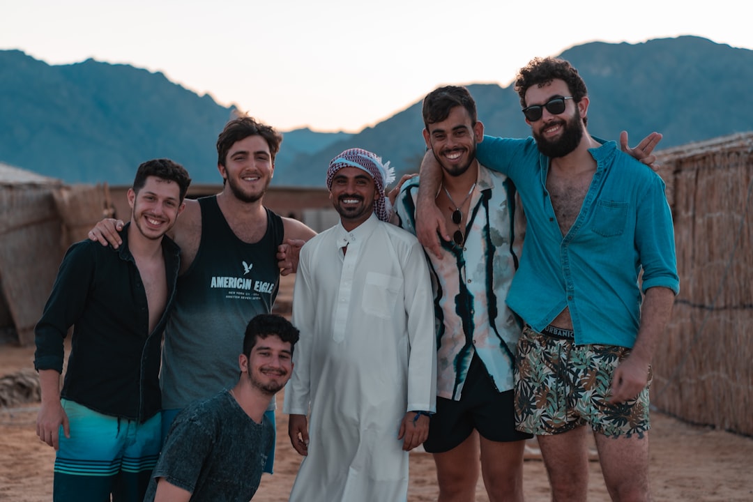 group of people standing on white sand during daytime