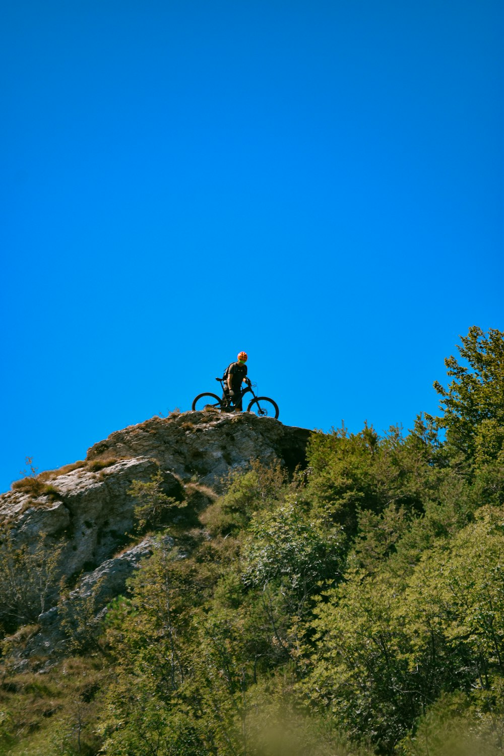 person in black shirt climbing on rocky mountain during daytime