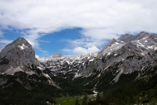 green and white mountains under blue sky and white clouds during daytime in Triglav National Park Slovenia