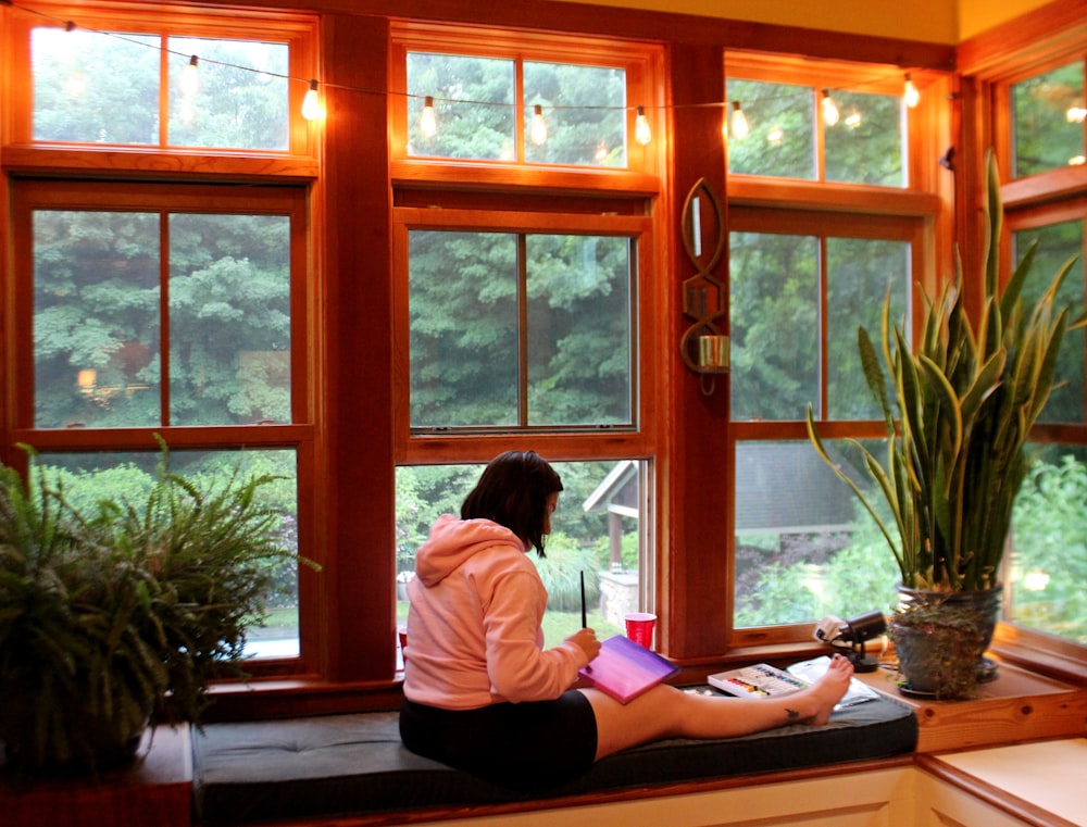 woman in white long sleeve shirt sitting on brown wooden table