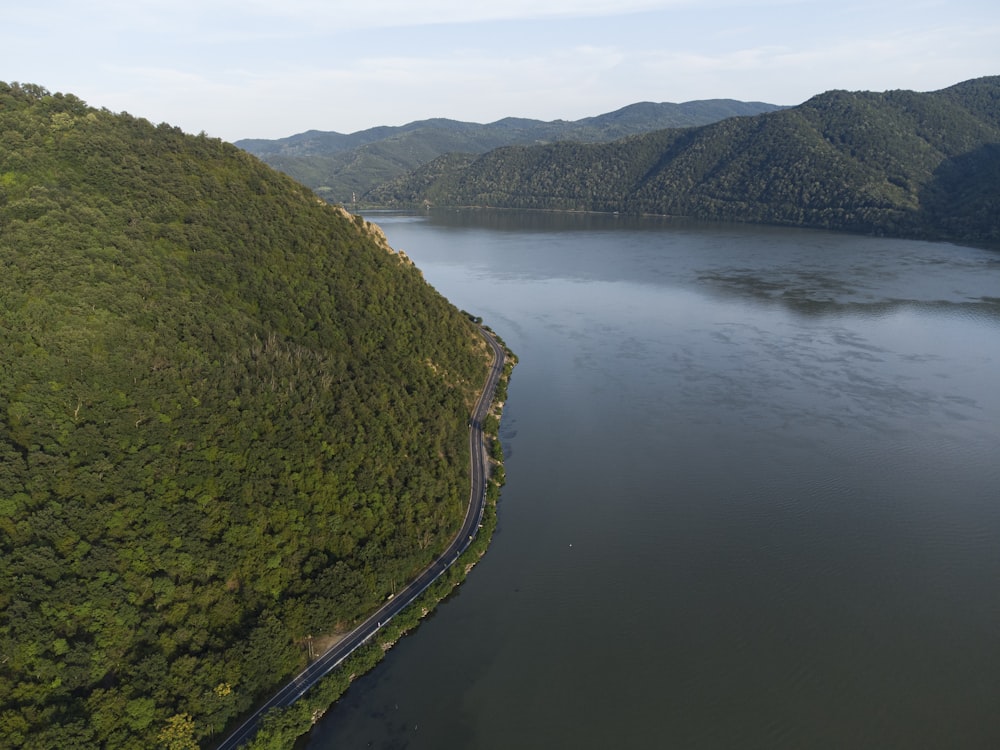 green mountain beside body of water during daytime