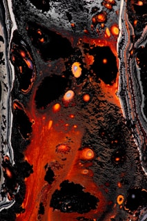 Abstract dark energy patterns swirling with magma-orange highlights.