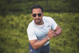man in white crew neck t-shirt and blue shorts wearing black sunglasses