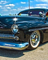 blue classic car on grey concrete road during daytime