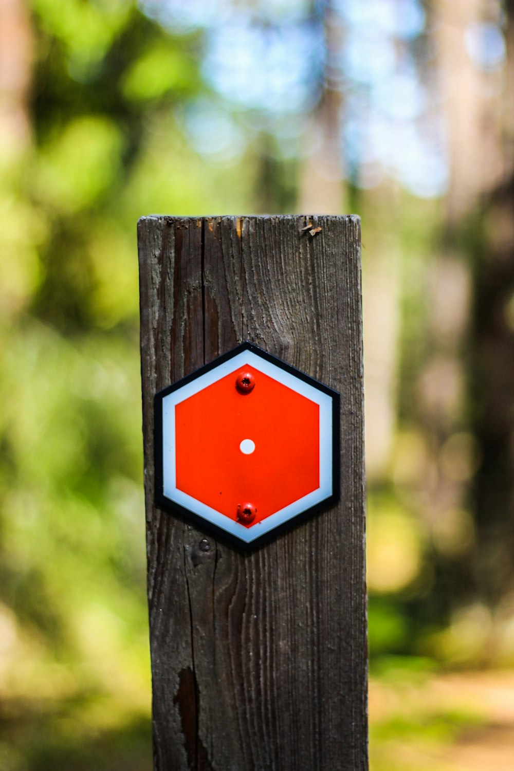 red and black square sign on brown wooden post