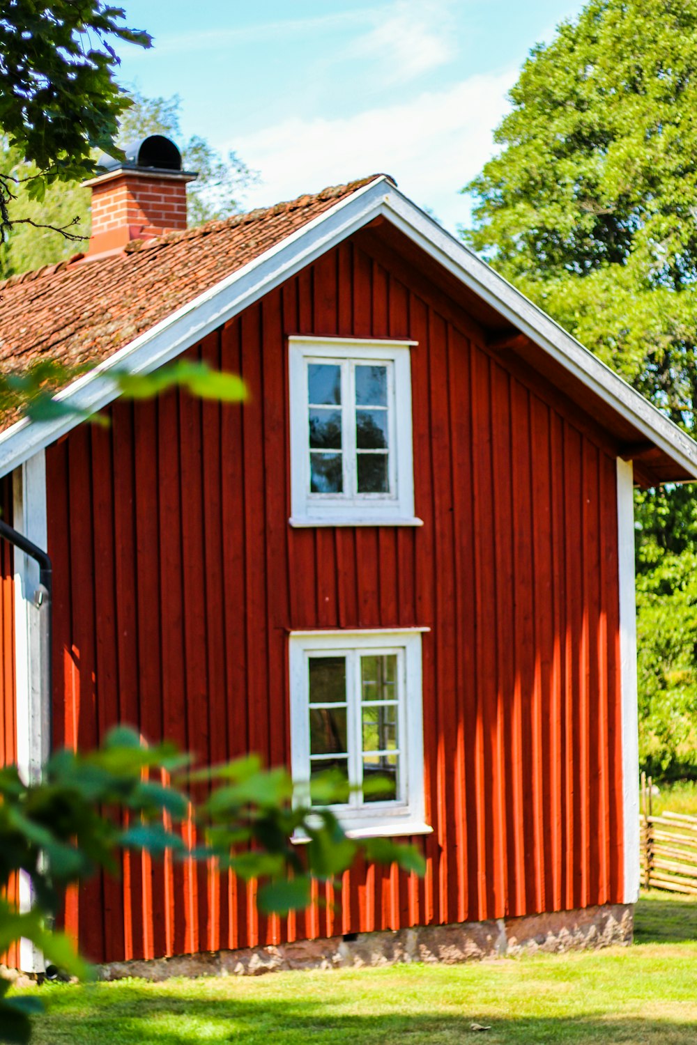 red and white wooden house near green trees during daytime