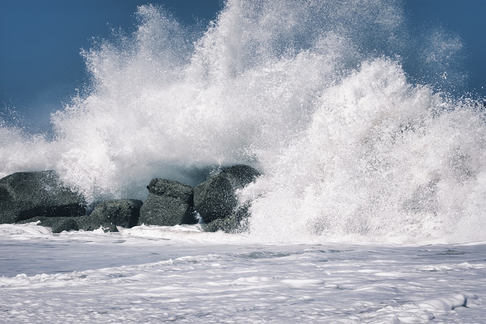 ocean waves crashing on rock formation during daytime