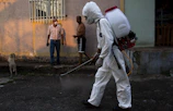 man in white pants holding black hose