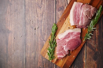 raw meat on brown wooden chopping board