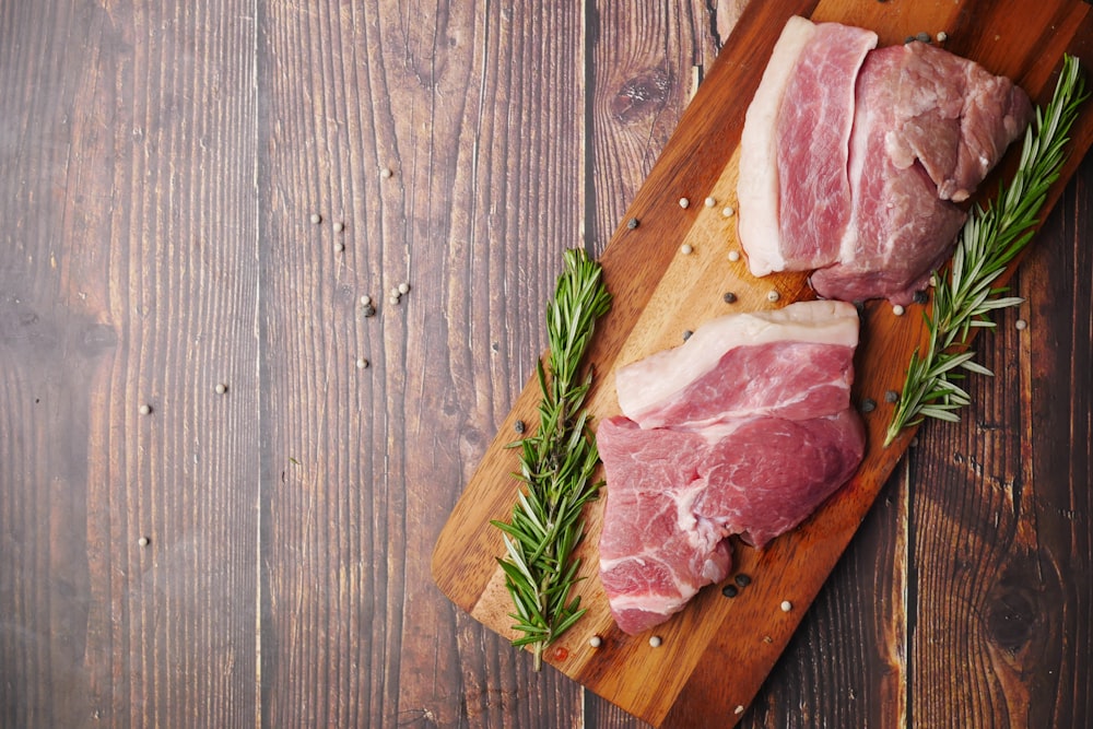 raw meat on brown wooden chopping board