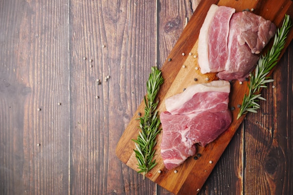 Raw meat on brown wooden chopping board