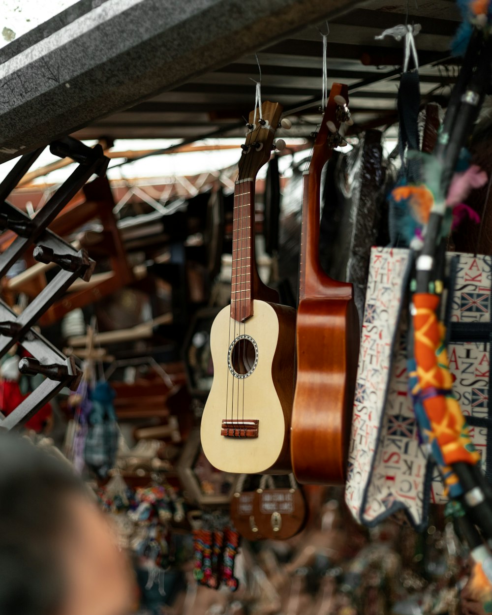 brown acoustic guitar hanged on black metal rack