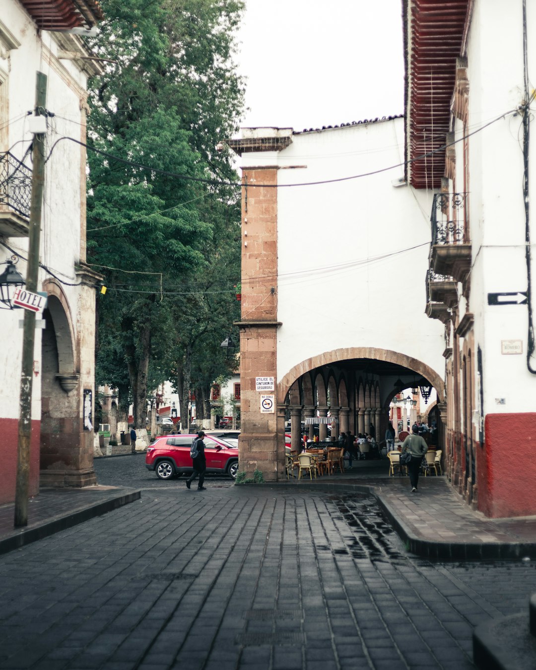 red car parked beside brown concrete building during daytime